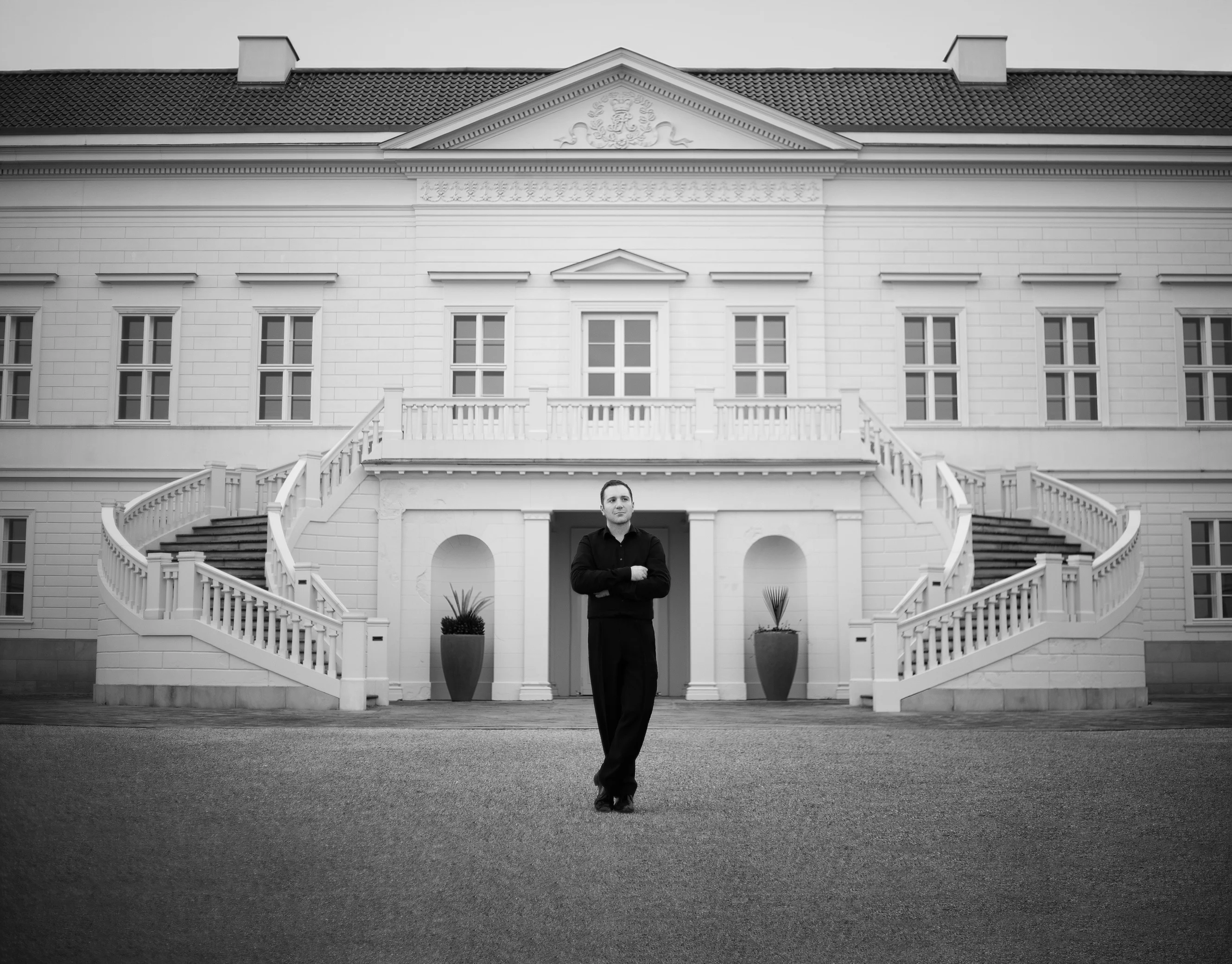 a black and white photo of a person standing in front of a large building